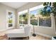Bright sitting room with a lounge chair and floor lamp situated in front of a large window with a neighborhood view at 2264 Savannah River St, Henderson, NV 89044