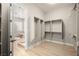 Bright walk-in closet showing wood floor and shelving system next to glass-enclosed shower at 2264 Savannah River St, Henderson, NV 89044