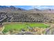 A beautiful aerial view of a neighborhood with green spaces, a playground, and mountain views at 244 Native Stone St, Las Vegas, NV 89138