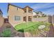 Backyard showcasing putting green with desert landscaping, block fence, and modern two-story house at 244 Native Stone St, Las Vegas, NV 89138