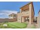 Rear view of home showcasing putting green, desert landscaping, stucco, and second story balcony at 244 Native Stone St, Las Vegas, NV 89138