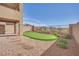 View of a backyard featuring putting green and low maintenance desert landscaping and block wall at 244 Native Stone St, Las Vegas, NV 89138