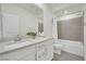 Modern bathroom with dual vanity, white cabinets, tiled shower, and gray tiled flooring at 244 Native Stone St, Las Vegas, NV 89138