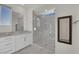 Modern bathroom featuring a glass shower enclosure, white marble-look tile, and white cabinetry at 244 Native Stone St, Las Vegas, NV 89138