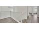 Upstairs hallway with wood-look floors and white banister overlooking the stairs at 244 Native Stone St, Las Vegas, NV 89138