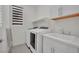 Modern laundry room with stainless steel washer and dryer, sleek countertops, and a window at 244 Native Stone St, Las Vegas, NV 89138