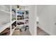 Organized pantry with white shelving, household items, and wood-look flooring at 244 Native Stone St, Las Vegas, NV 89138