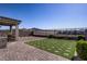 Spacious backyard features patio, artificial turf, retaining wall, and views of hills in the distance at 2581 Tolmezzo St, Henderson, NV 89044
