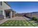 Large backyard with patio, artificial turf, desert landscaping, and view fence at 2581 Tolmezzo St, Henderson, NV 89044