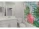 Bright bathroom features a single vanity and shower/tub combo with colorful floral shower curtain at 2581 Tolmezzo St, Henderson, NV 89044
