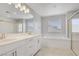 Bright bathroom featuring double sinks, sleek fixtures, soaking tub and glass shower at 2581 Tolmezzo St, Henderson, NV 89044