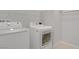 White laundry room features modern washer and dryer, wire shelving, and neutral walls and carpet at 2581 Tolmezzo St, Henderson, NV 89044