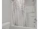 Shower-tub combination with sleek shower head and white shower curtain with leaf pattern at 2581 Tolmezzo St, Henderson, NV 89044