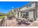 Brick backyard with dining set, lounge swing, grill, and black metal fencing at 2657 Fawn Beige Ct, North Las Vegas, NV 89086