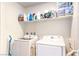Functional laundry room features a modern washer and dryer and convenient overhead shelving for ample storage at 2657 Fawn Beige Ct, North Las Vegas, NV 89086