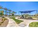 Community playground with shade cover, slide, and fun, imaginative play equipment amidst lush landscaping at 2657 Fawn Beige Ct, North Las Vegas, NV 89086