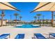 Community pool area featuring palm trees, lounge chairs, and covered seating at 2657 Fawn Beige Ct, North Las Vegas, NV 89086