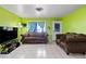 Cozy living room with tile floors, vibrant green walls, sofas, and lots of light at 2809 Webster St, North Las Vegas, NV 89030