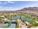 Expansive aerial shot showcasing a community with tennis courts, a golf course, lush landscaping, and scenic mountain views at 2885 Red Springs Dr, Las Vegas, NV 89135