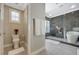 Modern bathroom featuring a sleek toilet, floating towels, and a shower with a luxurious tub at 2885 Red Springs Dr, Las Vegas, NV 89135
