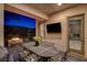Outdoor dining area on a covered patio with a mounted TV, fireplace, and views of the landscape at 2885 Red Springs Dr, Las Vegas, NV 89135