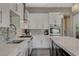Stylish kitchen with white cabinetry, stainless steel appliances, quartz countertops and a mosaic backsplash at 2885 Red Springs Dr, Las Vegas, NV 89135