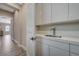 Convenient laundry room with white cabinets, sink, quartz countertop, and access to the rest of the home at 2885 Red Springs Dr, Las Vegas, NV 89135