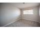 Neutral bedroom with gray carpet, white baseboard trim and a window with wood blinds; an electrical outlet is visible at 3025 Yankee Clipper Dr, Las Vegas, NV 89117