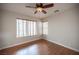 Neutral bedroom featuring wood-look flooring, baseboard trim and a ceiling fan with attached light fixture at 3025 Yankee Clipper Dr, Las Vegas, NV 89117