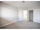 Bedroom featuring gray carpet, white trim, and a closet and entry door with views of the kitchen beyond at 3025 Yankee Clipper Dr, Las Vegas, NV 89117