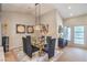 Modern dining room with a glass-topped table, chandelier, black velvet chairs, and sophisticated decor at 3101 Hayden Ct, Las Vegas, NV 89134