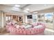 Bright, open living room with a tufted, curved sofa and natural light from skylights and picture window at 3101 Hayden Ct, Las Vegas, NV 89134
