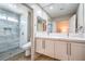 Modern bathroom featuring double sinks, white cabinets, and a glass-enclosed shower with marble tiling at 3101 Hayden Ct, Las Vegas, NV 89134