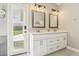 Bright bathroom boasts dual sinks, white cabinetry, and a door to the outside at 3249 Palmdesert Way, Las Vegas, NV 89120