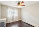 Cozy bedroom with dark wood floors, a window with curtains, and a ceiling fan at 3249 Palmdesert Way, Las Vegas, NV 89120