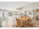 Dining room with rustic table, woven chairs, and access to the kitchen and outdoor patio with a pool at 3249 Palmdesert Way, Las Vegas, NV 89120