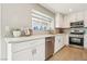 Bright kitchen features stainless steel appliances, white cabinets and gray subway tile backsplash at 3249 Palmdesert Way, Las Vegas, NV 89120