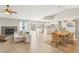 Open-concept living room with fireplace, tile floors, vaulted ceilings, and access to kitchen and outdoor patio at 3249 Palmdesert Way, Las Vegas, NV 89120