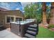 Outdoor hot tub with steps, surrounded by turf and desert landscaping at 3696 Waynesvill St, Las Vegas, NV 89122