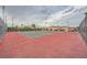 Outdoor tennis court on a partly cloudy day with view of adjacent property and ample lighting at 4338 Caliente St # 11, Las Vegas, NV 89119
