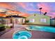 Resort-style backyard featuring a refreshing pool, hot tub, covered patio, and desert landscaping at sunset at 4623 Kearney St, Las Vegas, NV 89147