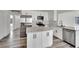 Modern kitchen with stainless steel appliances, kitchen island, and wood-look flooring at 4623 Kearney St, Las Vegas, NV 89147