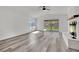 Bright living room features new gray flooring, a brick fireplace, and a sliding door to the backyard at 4623 Kearney St, Las Vegas, NV 89147
