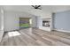 Bright living room features new gray flooring, a brick fireplace, ceiling fan, and a sliding door to the backyard at 4623 Kearney St, Las Vegas, NV 89147