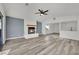 Bright living room features gray flooring, a brick fireplace, ceiling fan, and an open view to the kitchen at 4623 Kearney St, Las Vegas, NV 89147