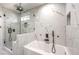 Modern bathroom featuring marble tiles, a soaking tub, and a glass enclosed shower at 4774 San Sebastian Ave, Las Vegas, NV 89121