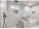 Shower and tub featuring marble walls, pebble accents, and a glass partition at 4774 San Sebastian Ave, Las Vegas, NV 89121
