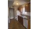 Functional kitchen featuring wood cabinets, granite countertops, white appliances, and tile floors at 5248 Greene Ln # B, Las Vegas, NV 89119