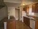 Bright kitchen with wood cabinetry, granite counters, tile floor, and white appliances at 5248 Greene Ln # B, Las Vegas, NV 89119