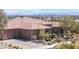 Stunning home featuring a three-car garage, stone details, desert landscaping, and tile roof at 5410 Serenity Brook Dr, Las Vegas, NV 89149